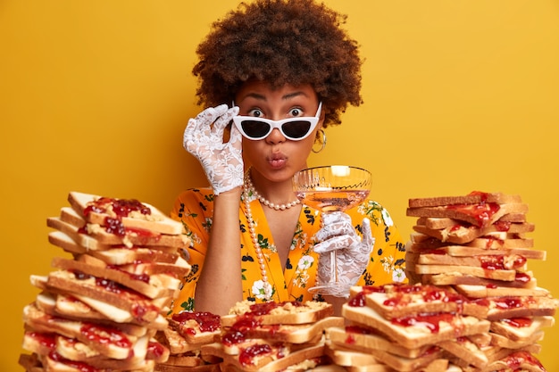 Attraente donna con i capelli afro circondato da panini gelati al burro di arachidi