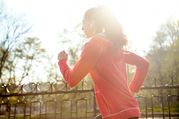 Attraente donna felice che fa jogging nel parco