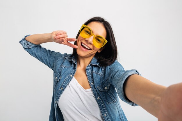 Attraente donna felice sorridente che fa selfie foto isolato su bianco studio