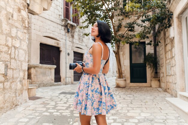 Attraente donna in abito treveling in vacanza nel centro storico della città italiana a scattare foto sulla fotocamera