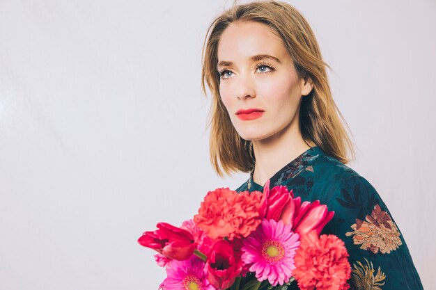 Attraente donna sicura con bouquet di fiori