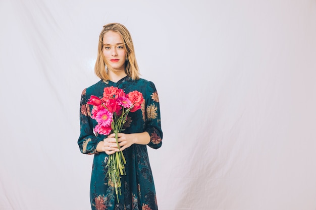 Attraente donna sicura con bouquet di fiori