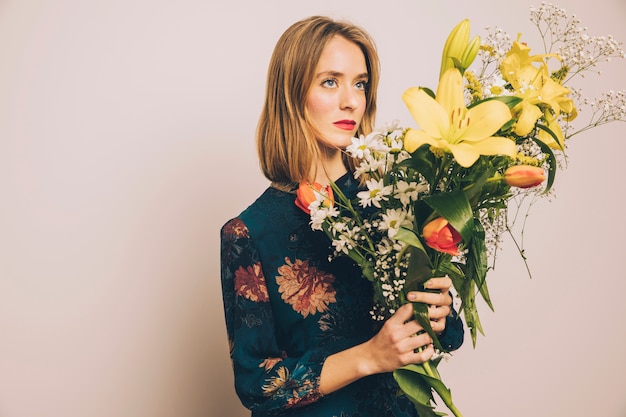 Attraente donna sicura con grande mazzo di fiori