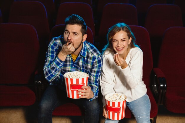 Attraente giovane coppia caucasica guardando un film in un cinema, casa o cinema.