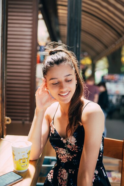 Attraente giovane donna caucasica seduto in street cafe