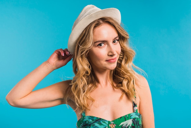 Attraente giovane donna in abito a fiori e cappello