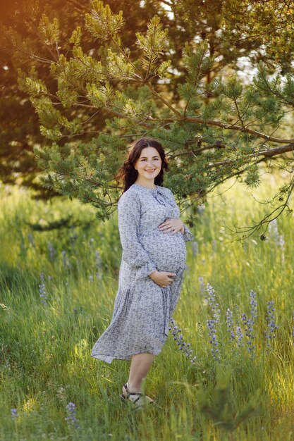Attraente giovane donna incinta fuori