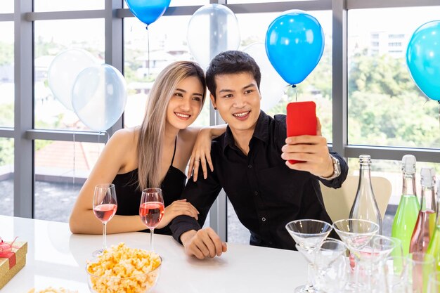 Attraente giovane maschio e femmina celebrano Natale e Capodanno in ufficio festa uomo e donna che prendono selfie insieme