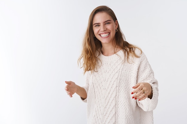 Attraente sincero dall'aspetto amichevole spensierato felice affascinante donna taglio di capelli corto che indossa un maglione allentato e accogliente che ride godendo di una fantastica compagnia divertente scherzando, sorridendo felicemente divertendosi sfondo bianco