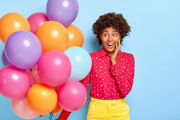 Auguri di compleanno. Signora positiva con acconciatura afro, sguardi da parte