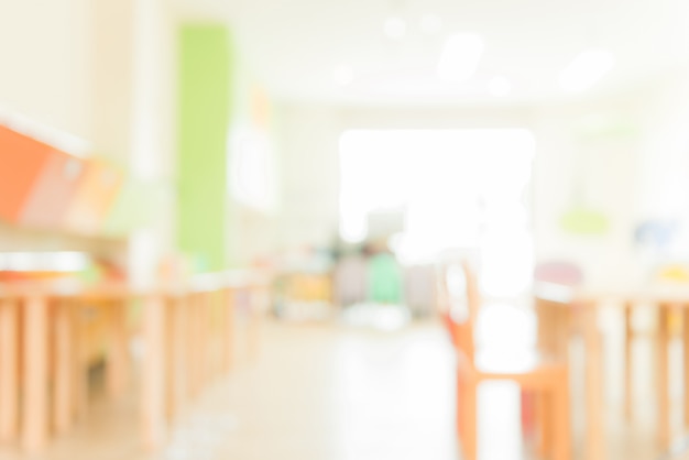 Aula scolara in sfocatura sfondo senza giovane studente; Vista sfocata della sala di classe elementare nessun ragazzo o insegnante con sedie e tavoli nel campus. Immagini di stile d&#39;effetto vintage.