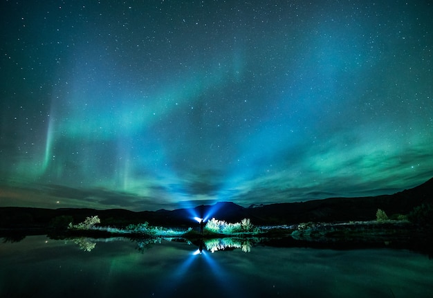 Aurora verde si accende sopra lo specchio d'acqua