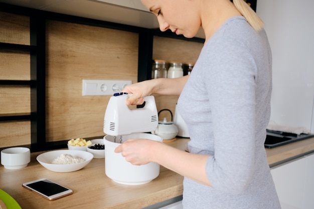 Autentica donna che utilizza un mixer portatile