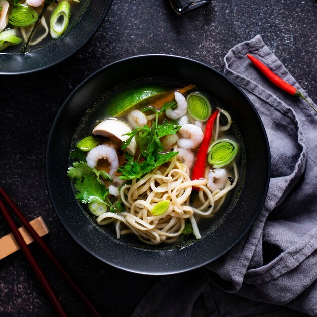 Autentica zuppa di noodles asiatica in una ciotola nera