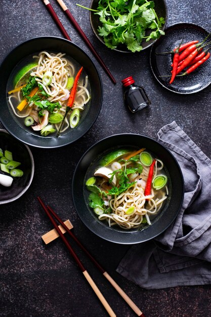 Autentica zuppa di noodles asiatica in una ciotola nera