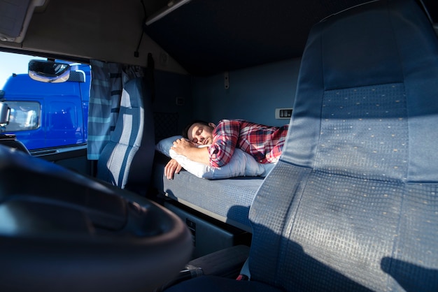 Autista di camion che dorme sul letto all'interno della cabina del camion