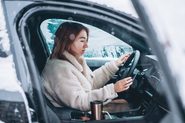 Autista donna attraente seduto dietro il volante della sua auto