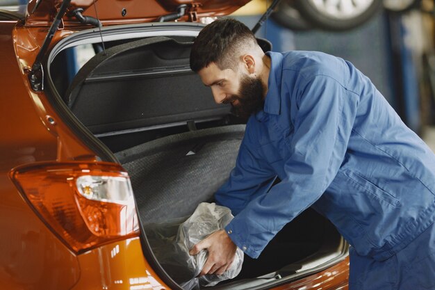 Auto in garage. Ragazzo in abiti da lavoro. Barbanera.