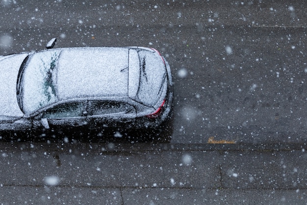 Auto nera sulla strada sotto la neve in primavera a Nuova Zagabria, Croazia