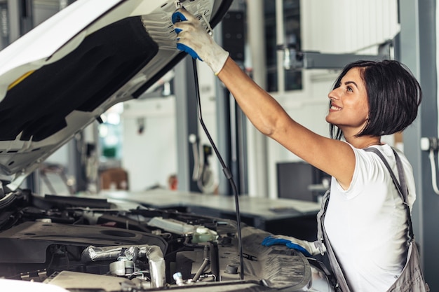 Automobile femminile della riparazione del meccanico di vista laterale