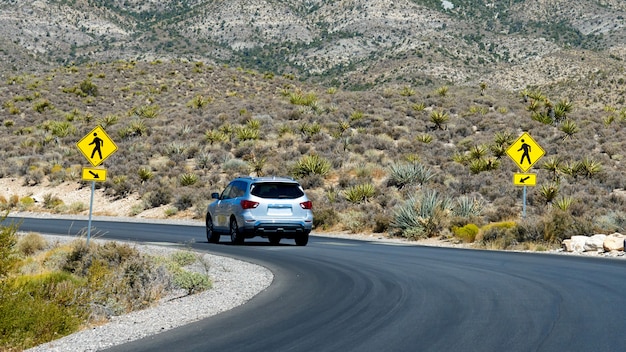 Automobile sulla strada nel canyon rosso della roccia, Nevada, USA