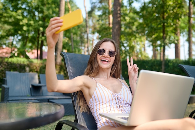 Autoscatto. Giovane donna eccitata felice che fa selfie