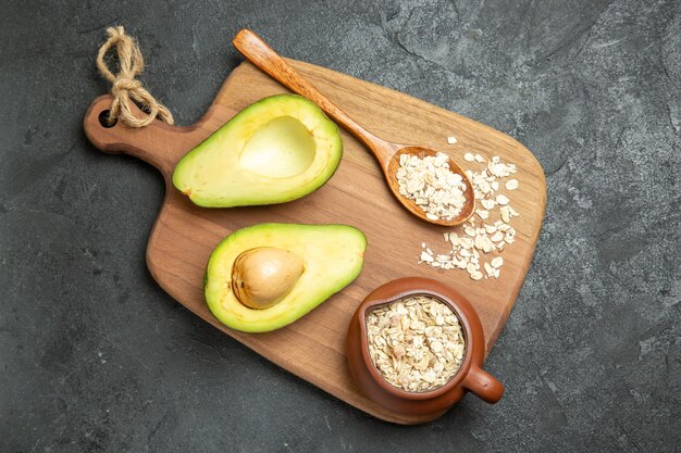 Avocado fresco vista dall'alto con cereali crudi su una colazione esotica di frutta superficie grigia fresca