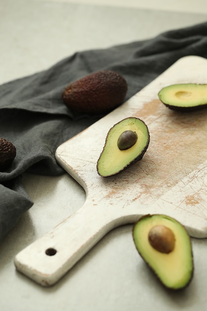 Avocado interi e tagliati sul tagliere di legno