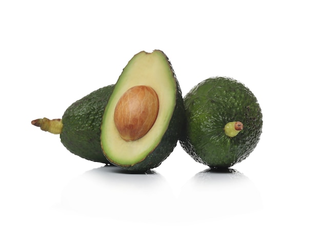 Avocado verdi su una superficie bianca