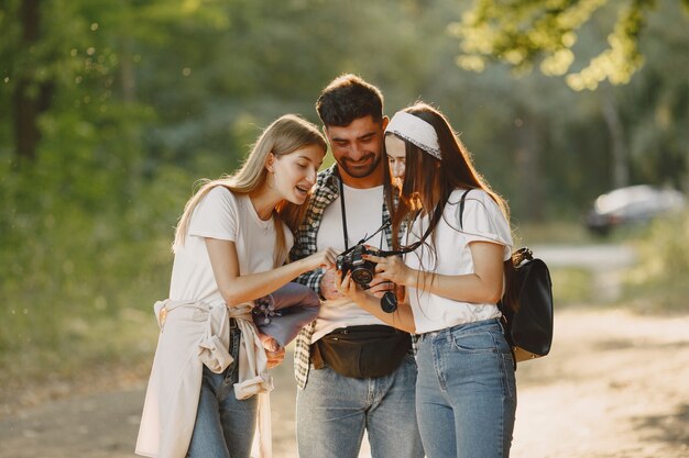 Avventura, viaggi, turismo, escursione e concetto di persone. Gruppo di amici sorridenti in una foresta.