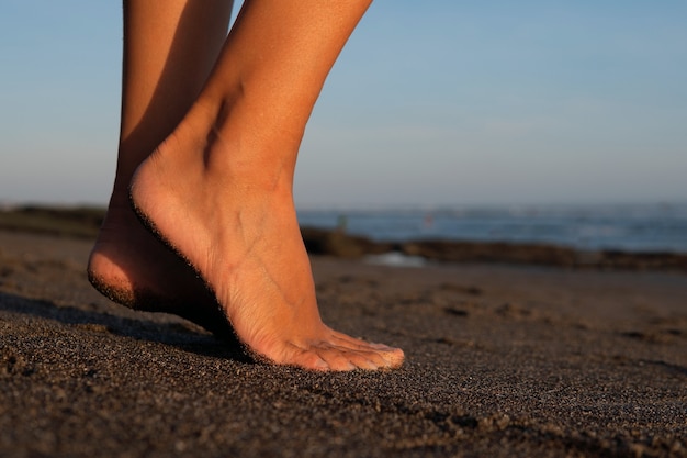 Avvicinamento. piedi sulla sabbia nera. bali