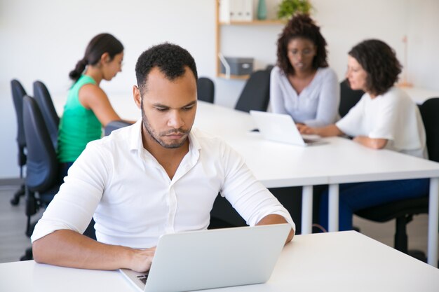 Azienda leader di successo seria che lavora al computer portatile