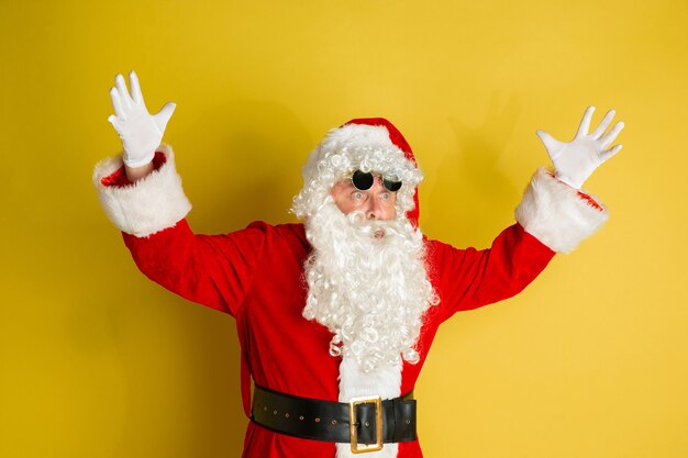 Babbo Natale con occhiali da vista moderni isolati su giallo