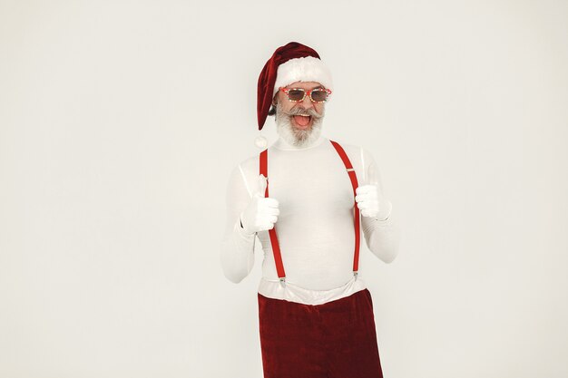 Babbo Natale dai capelli grigi alla moda. L'uomo indossa vestiti a maglia. Nonno in un cappello di Babbo Natale.