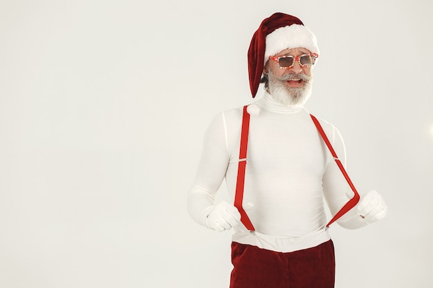 Babbo Natale dai capelli grigi alla moda. L'uomo indossa vestiti a maglia. Nonno in un cappello di Babbo Natale.