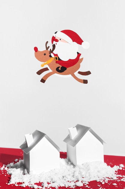 Babbo Natale e renne che volano sopra le case