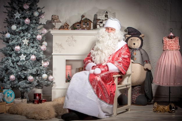 Babbo Natale felice che si siede sulle decorazioni natalizie