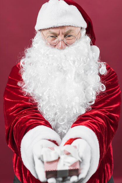 Babbo Natale in bicchieri tenendo piccolo regalo