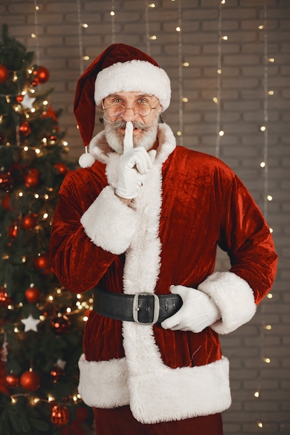 Babbo Natale in piedi vicino all'albero di Natale. Decorazioni per la casa.