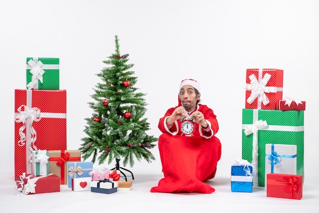 Babbo Natale seduto con scatole regalo e albero