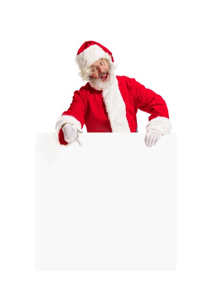 Babbo Natale sorpreso felice che indica sul fondo della bandiera della pubblicità in bianco con lo spazio della copia. Uomo maggiore sorridente che mostra allo spazio in bianco bianco del manifesto vuoto