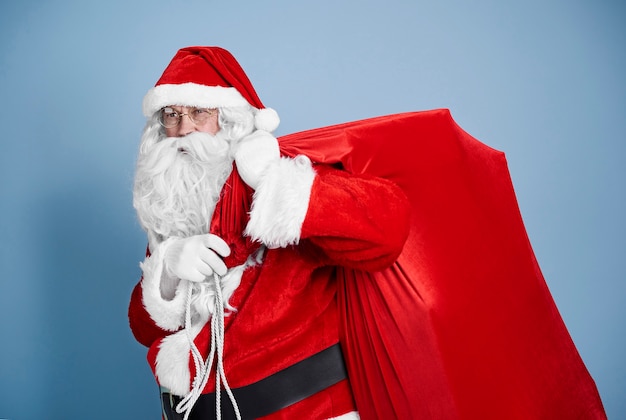 Babbo Natale stanco che trasporta un sacco pesante