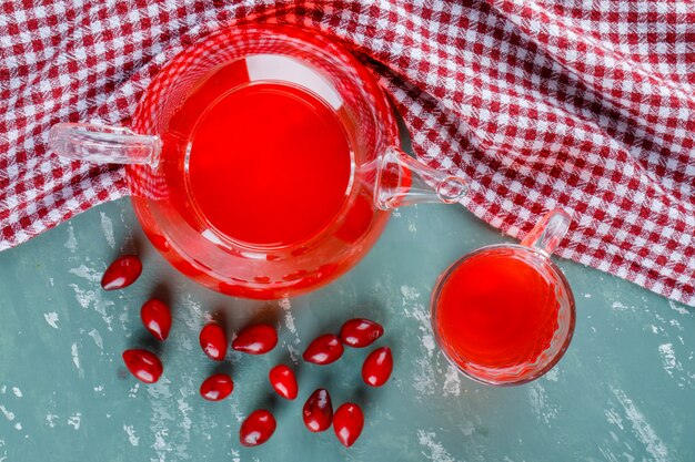 Bacche di corniolo con bevanda su intonaco e panno da picnic.