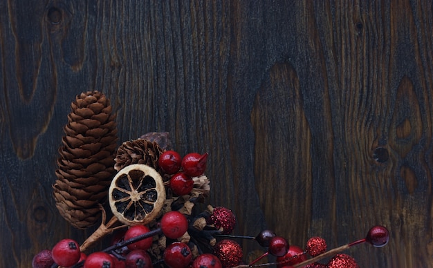 bacche di Natale e pigne su uno sfondo di legno