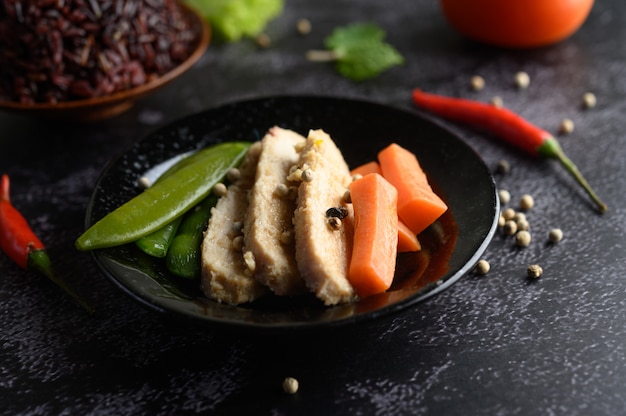 Bacche di riso viola cotte con petto di pollo grigliato. Zucca, carote e foglie di menta in un piatto, cibo pulito.