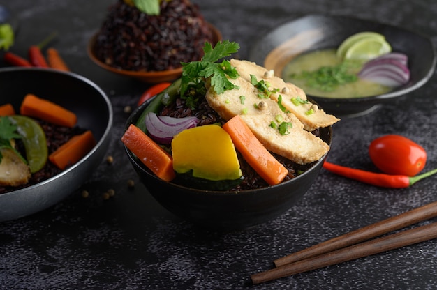 Bacche di riso viola cotte con petto di pollo grigliato. Zucca, carote e foglie di menta in un piatto, cibo pulito.