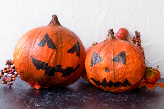 Bacche vicino a jack-o-lanterns di carta