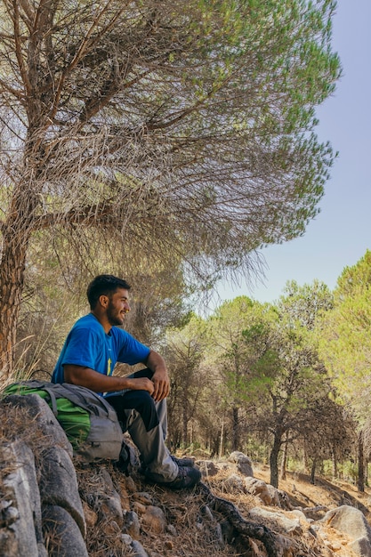 Backpacker che si raffredda sotto un albero