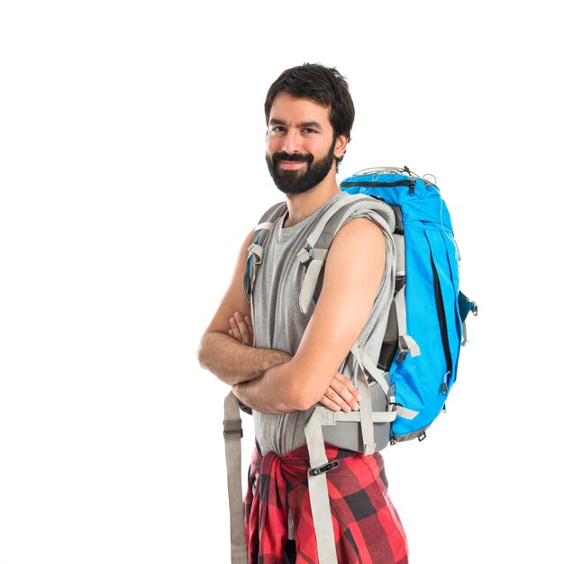Backpacker con le braccia incrociate su sfondo bianco