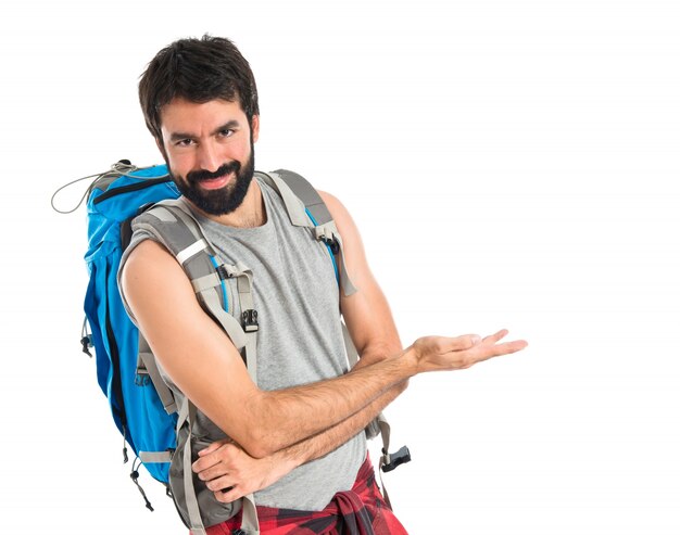 Backpacker presentando qualcosa su sfondo bianco isolato